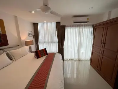 a bedroom with a bed and a large window at Super Som Rawai in Rawai Beach