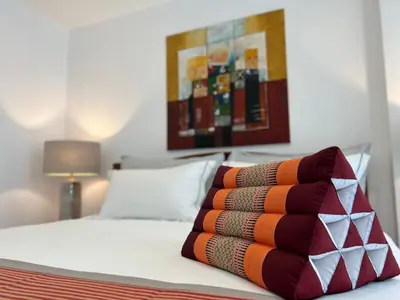 a bedroom with a bed with a pillow on it at Super Som Rawai in Rawai Beach