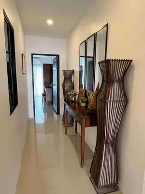 a living room with a wooden table and mirrors at Super Som Rawai in Rawai Beach