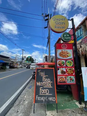 a sign on the side of a street next to a restaurant at Super Som Rawai in Rawai Beach