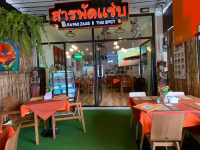 a restaurant with tables and chairs in front of a window at Super Som Rawai in Rawai Beach