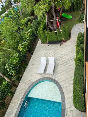 an overhead view of a swimming pool with two white benches at Seaside vacation in Rawai Beach
