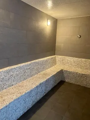 a bathtub in a room with a stone wall at Seaside vacation in Rawai Beach