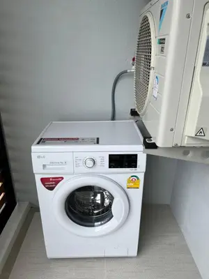 a washing machine with a microwave on top of it at Seaside vacation in Rawai Beach