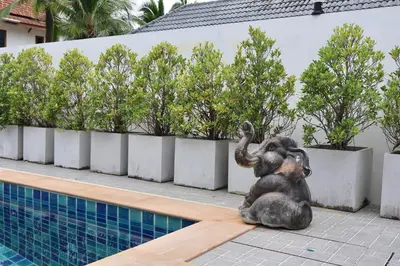 a statue of an elephant sitting next to a swimming pool at Kamala - Chonlada Holiday Home 2 BR Residence in Kamala Beach
