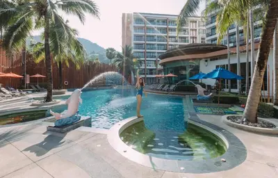 a woman standing in front of a fountain in a pool at The Beach Heights Condotel Kata 500 meters to Kata beach in Kata Beach