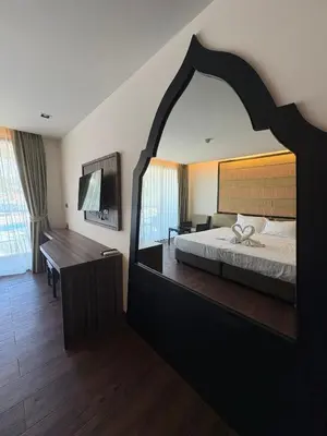 a bedroom with a bed and a large mirror at The Beach Heights Condotel Kata 500 meters to Kata beach in Kata Beach