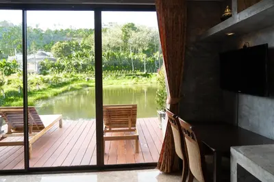a dining room with a view of a river at Anodard Phuket, Nai Yang Beach in Thalang