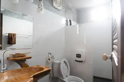 a bathroom with a wooden sink and a toilet at Anodard Phuket, Nai Yang Beach in Thalang