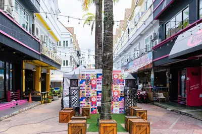 a street in a city with trees and benches at Slumber Surf Phuket Kata in Kata Beach