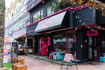 a store front with tables and chairs in a street at Slumber Surf Phuket Kata in Kata Beach