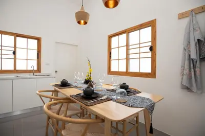 a dining room with a wooden table and chairs at Villa Sunrise Garden A180 in Thalang