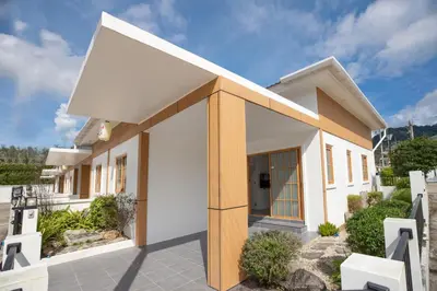 a white house with a brown and white facade at Villa Sunrise Garden A180 in Thalang