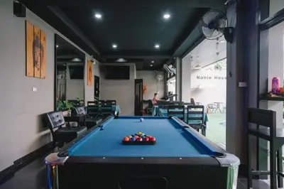 a pool table in a room with chairs and a pool table at Noble House Patong in Patong Beach