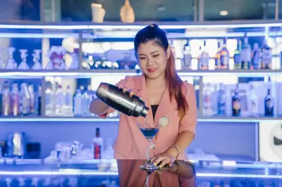 a woman pouring a drink in a martini glass at Noble House Patong in Patong Beach