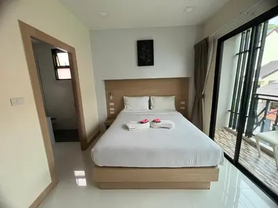 a bedroom with a bed with two towels on it at I AM O'TEL Patong in Patong Beach