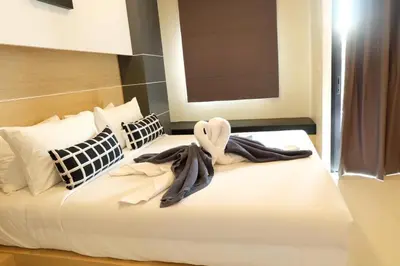 a bedroom with a bed with a towel on it at I AM O'TEL Patong in Patong Beach
