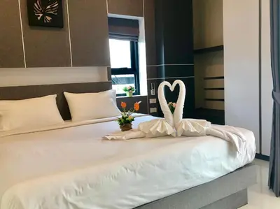 a white bed with a swan decoration on it at I AM O'TEL Patong in Patong Beach