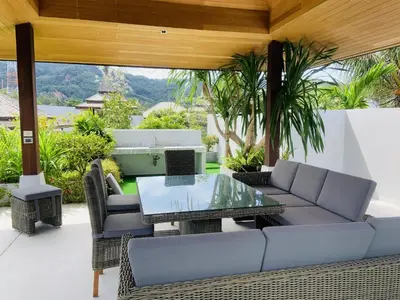 a patio with a couch and a table at Villa Jasmine - luxury private villa Bangtao Beach in Bang Tao Beach