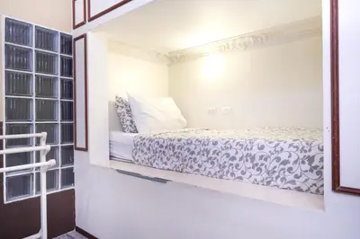a bedroom with a bed in a room with a window at Guesthouse Phuket Airport in Ban Bo Han