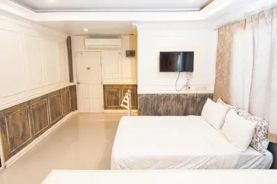 a hotel room with two beds and a tv at Guesthouse Phuket Airport in Ban Bo Han