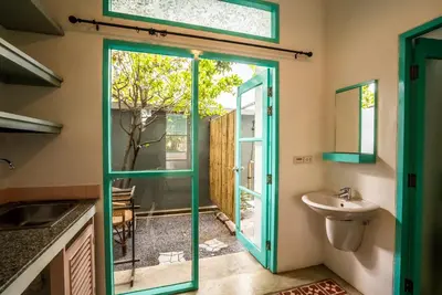a bathroom with a green door and a sink at Nomads Ao Nang Party Hostel 18-35 Years Old Only in Ao Nang Beach