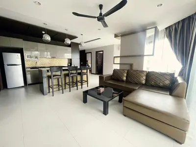 a living room and kitchen with a couch and a table at The Regent Bangtao Apartments in Bang Tao Beach