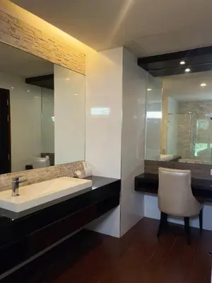a bathroom with a sink and a chair and a mirror at The Regent Bangtao Apartments in Bang Tao Beach