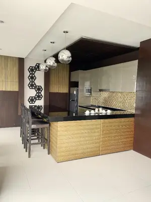 a kitchen with a counter and a dining room at The Regent Bangtao Apartments in Bang Tao Beach