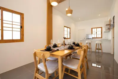 a dining room with a wooden table and chairs at Villa Sunrise Garden B190 in Thalang