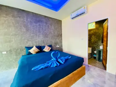 a bedroom with a blue bed with a blue bow on it at Kohyao Non Bay in Ko Yao Yai