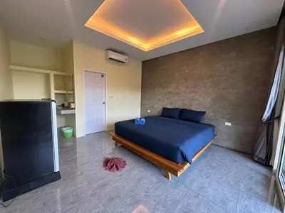 a bedroom with a bed with a blue comforter at Kohyao Non Bay in Ko Yao Yai