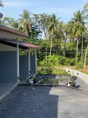 a building with palm trees in the background at Kohyao Non Bay in Ko Yao Yai