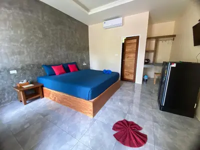 a bedroom with a blue bed and a television at Kohyao Non Bay in Ko Yao Yai