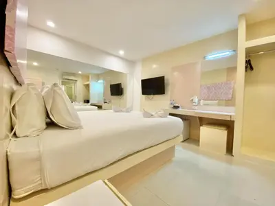 a hotel room with a large bed and a sink at Patong Platinum in Patong Beach