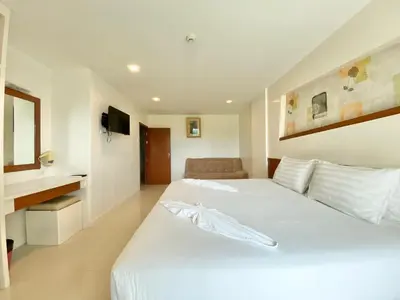 a bedroom with a large white bed and a couch at Patong Platinum in Patong Beach