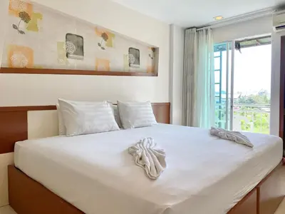 a bedroom with a large white bed with a window at Patong Platinum in Patong Beach