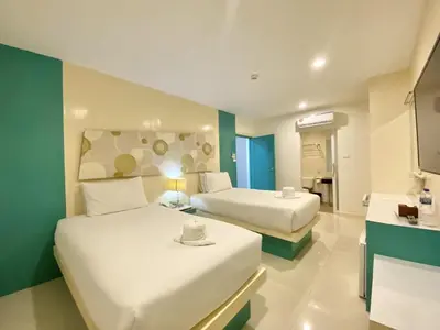 a hotel room with two beds and a bathroom at Patong Platinum in Patong Beach