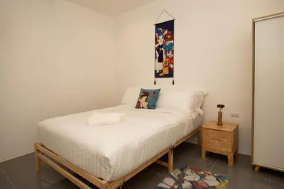 a small bedroom with a bed with white sheets at Villa Sunrise Garden B191 in Thalang