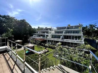 a large white apartment building with a garden at Spectacular Ocean View Apartment in Ban Saiyuan (1)