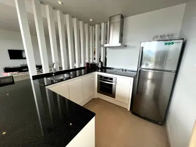 a kitchen with a stainless steel refrigerator and black counter top at Spectacular Ocean View Apartment in Ban Saiyuan (1)