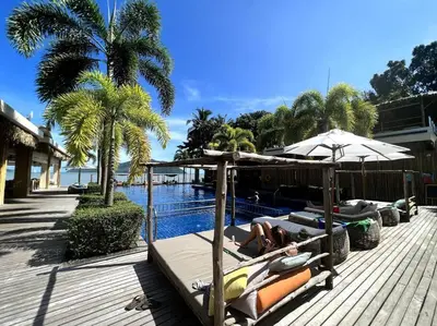 a woman laying on a raft next to a swimming pool at Spectacular Ocean View Apartment in Ban Saiyuan (1)