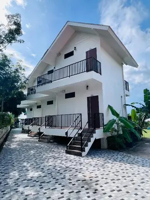 a white building with stairs on the side of it at White Seaview Residence in Klong Muang Beach