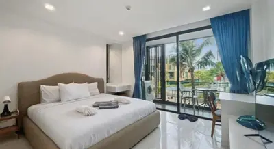 a bedroom with a bed and a view of a patio at Pixels - Ocean Front Studio with Pool View Cape Panwa in Ban Ao Makham