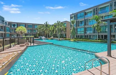 a swimming pool in front of a building at Pixels - Ocean Front Studio with Pool View Cape Panwa in Ban Ao Makham