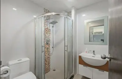 a bathroom with a shower and a toilet and a sink at Pixels - Ocean Front Studio with Pool View Cape Panwa in Ban Ao Makham