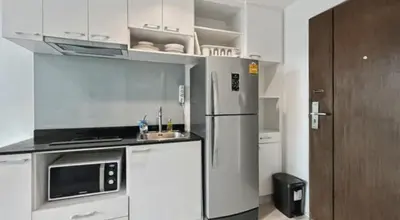 a small kitchen with a refrigerator and a sink at Pixels - Ocean Front Studio with Pool View Cape Panwa in Ban Ao Makham