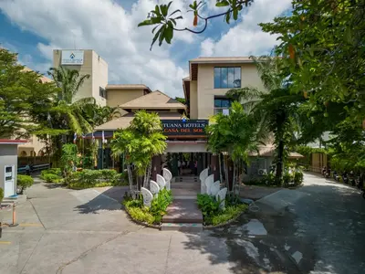 a hotel with white chairs in front of a building at Tuana Hotels Casa Del Sol in Kata Beach