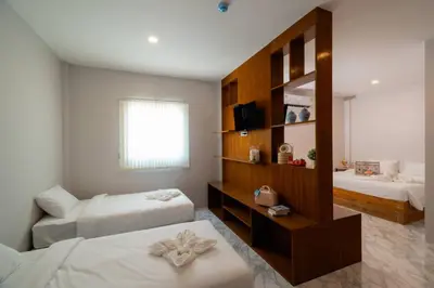 a hotel room with two beds and a television at Terminal 58 Airport in Ban Mut Dok Khao