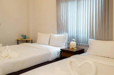 a hotel room with two beds and a window at Terminal 58 Airport in Ban Mut Dok Khao